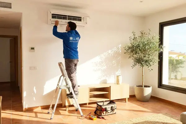 Técnico de VLR Instalaciones revisando un aire acondicionado en una vivienda de Málaga en verano