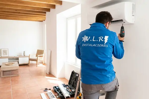 Electricista de VLR Instalaciones instalando un aire acondicionado split en una vivienda de Málaga