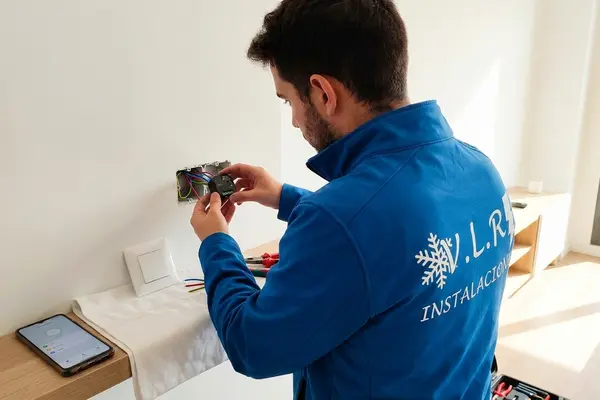 Electricista de VLR Instalaciones instalando un módulo domótico en la caja de un interruptor de una vivienda
