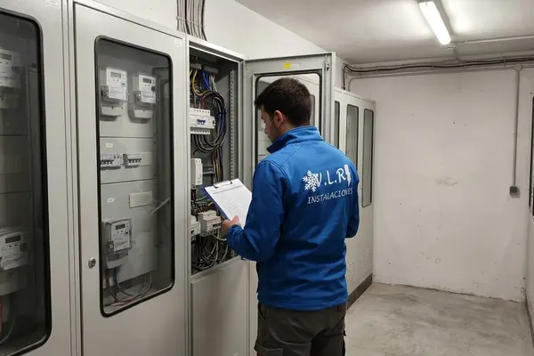Electricista de VLR Instalaciones revisando con una lista de comprobación el cuarto de contadores de un edificio