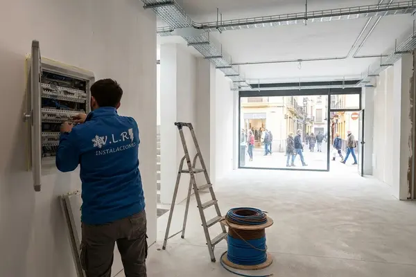 Electricista de VLR Instalaciones trabajando en el cuadro eléctrico de un local comercial en obra en Málaga