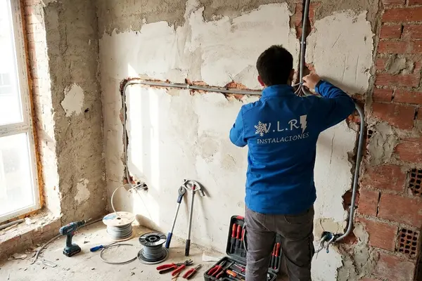 Electricista de VLR Instalaciones pasando cableado nuevo durante la reforma eléctrica de una vivienda