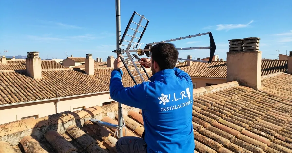 Electricista de VLR Instalaciones instalando una antena de televisión en un tejado de Málaga